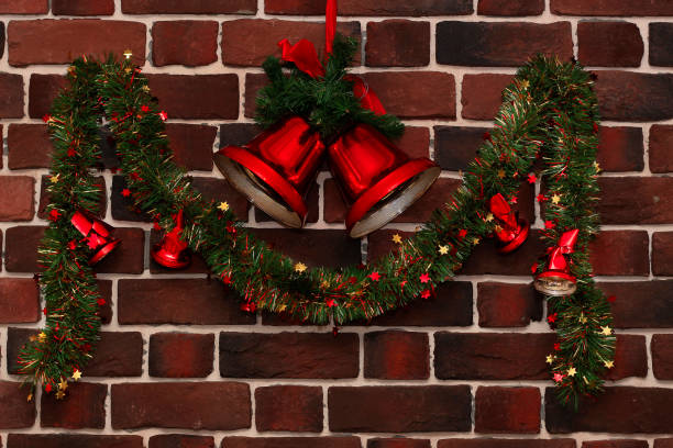 istock green garland with red bells on a brick wall 1218434920