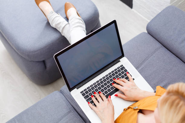 istock Happy pretty woman using laptop sitting on cosy sofa 1218435314
