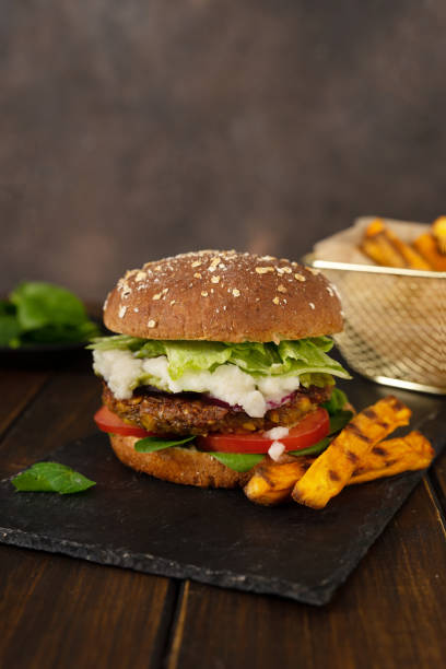 istock Vertical shot of home-made vegan lentils burger on a rustic dark background 1218438543
