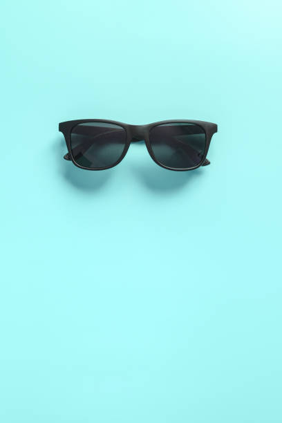 istock Black stylish sunglasses on blue background. Flat lay. Minimal style concept 1218438596