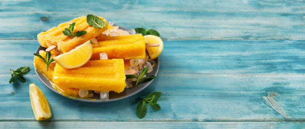 istock Vegan mango sorbet popsicles on trendy turquoise background 1218439775