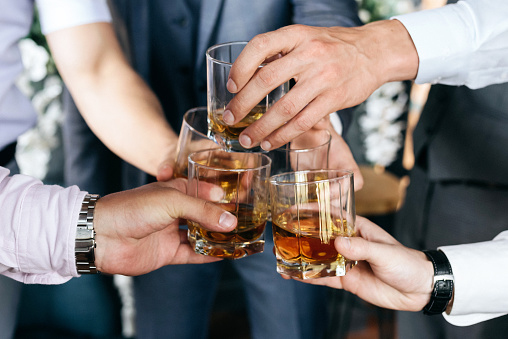 Cropped view of Group of friends guys with glasses of whiskey before wedding day