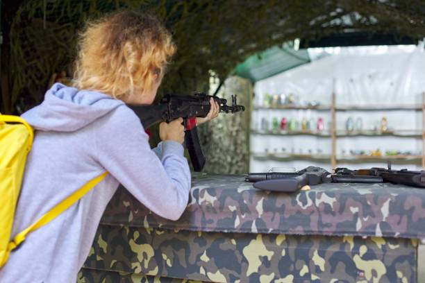 射撃場で訓練ライフルを撃つ10代の少女のクローズアップ - armed forces human hand rifle bullet ストックフォトと画像