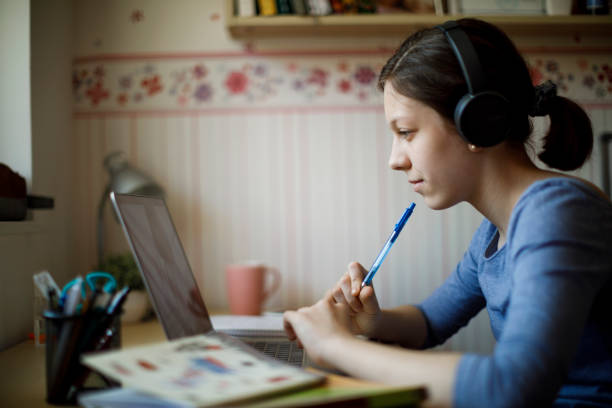 Teenage girl studying with video online lesson at home Teenage girl studying with video online lesson at home professor business classroom computer stock pictures, royalty-free photos & images