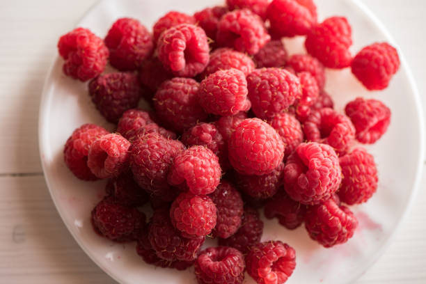 istock fresh organic ripe raspberries on a small white porcelain plate 1218440066