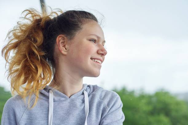 closeup portrait of teenage girl of 14, 15 years old in gray sweatshirt - teenager 14 15 years 13 14 years cheerful imagens e fotografias de stock