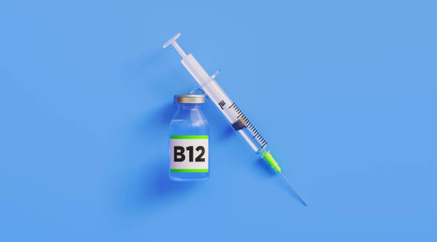 istock Injectable B12 Vitamin  and Syringe on Blue Background 1218443675