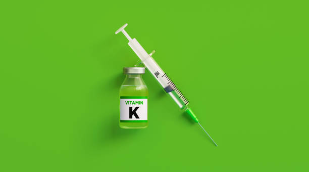 Injectable Vitamin K and Syringe on Green Background
