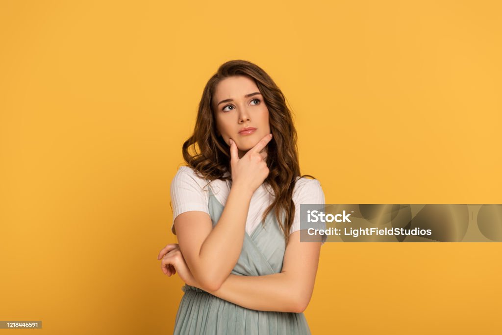 mujer de primavera reflexiva con el pelo largo aislado en amarillo - Foto de stock de Contemplación libre de derechos