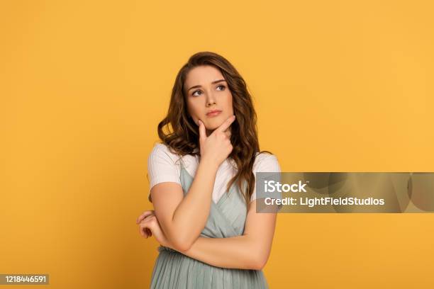 Mujer De Primavera Reflexiva Con El Pelo Largo Aislado En Amarillo Foto de stock y más banco de imágenes de Contemplación