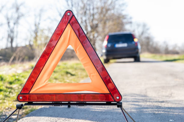 istock red warning triangle on the road in front of a broken car 1218450054