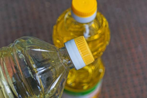 zwei geschlossene vollplastische flaschen mit gelbem sonnenblumenöl - sunflower seed oil stock-fotos und bilder