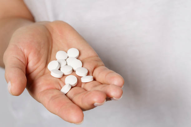 istock Female hand with a handful of pills 1218451337