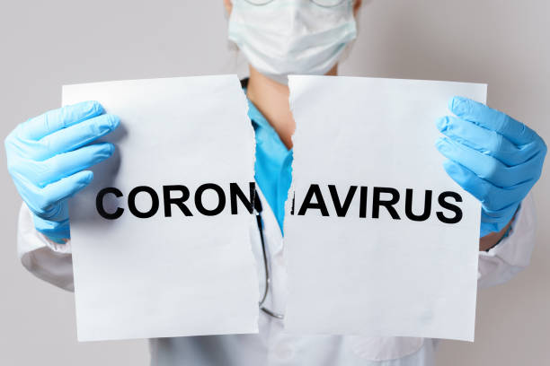 istock Doctor is torn the paper with a lettering coronavirus 1218452043