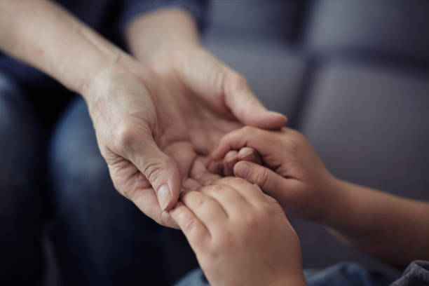 istock Grandson holding grandmother hands close up view 1218453920