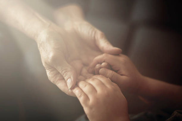 grandson holding grandmother hands close up view - holding hands human hand senior adult consoling imagens e fotografias de stock