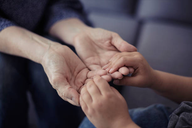 istock Grandson holding grandmother hands close up view 1218453967