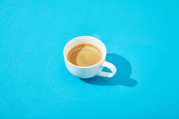 istock white cup of fresh coffee on blue background 1218458601