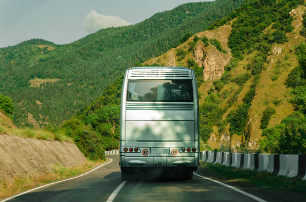 istock Rear side of bus. Back view. Blank white bus on mountain highway. 1218462459