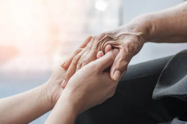 Photo of Parkinson disease patient, Alzheimer elderly senior, Arthritis person hand in support of nursing family caregiver care for disability awareness day, National care givers month, ageing society concept