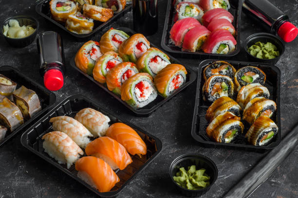 conjunto de rolos de sushi em uma caixa de plástico, entregue em casa pronto para comer comida rápida saudável - black dishware sushi isolated - fotografias e filmes do acervo