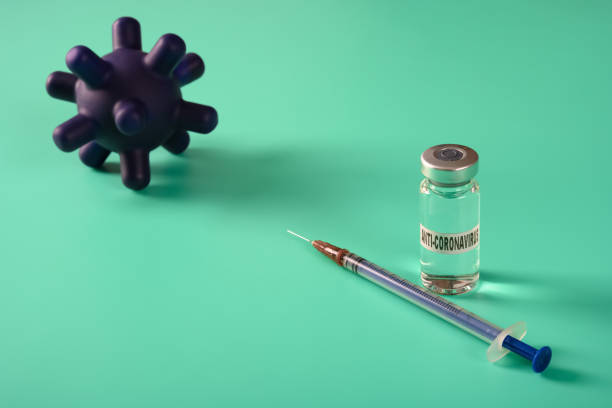 istock vaccine and syringe with coronavirus on back 1218471116