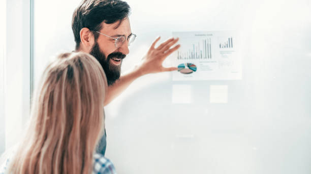 istock young entrepreneur pointing to a chart with financial data. 1218477308