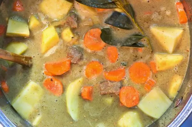 Photo of Thai beef coconut curry stew simmering in a pot.