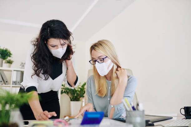 istock orking in office in surgical masks 1218486062