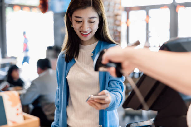istock Asian young woman paying with smartphone in a cafe. 1218486801