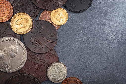 Numismatics. Old collectible coins made of silver, gold and copper on a wooden table. Top view. Copy space of your text.