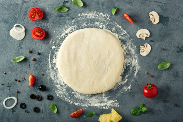 istock Ingredients and dough for homemade pizza on the table. Top view. 1218489980