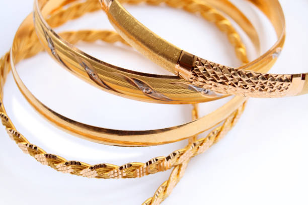istock various gold bracelets on a white background 1218492548