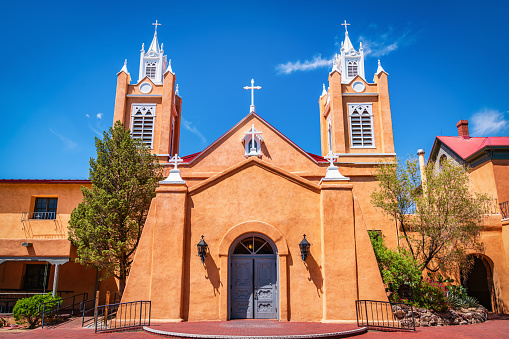 Historic San Felipe de Neri Church under blue summer sky. San Felipe de Neri Church is a historic catholic church at the Old Town Plaza in Albuquerque. Built in 1793, it is one of the oldest surviving buildings in the city of  Albuquerque and the only building in Old Town proven to date to the Spanish colonial period. Old Town Plaza Albuquerque, Downtown Albuquerque New Mexico, USA, North America