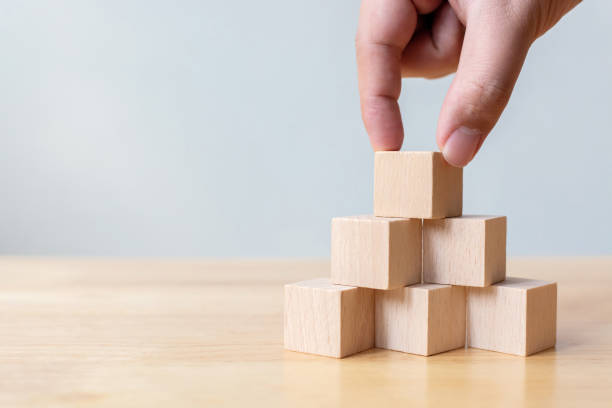 istock Hand arranging wood block stacking as step stair on top pyramid. Business concept for growth success process 1218495222