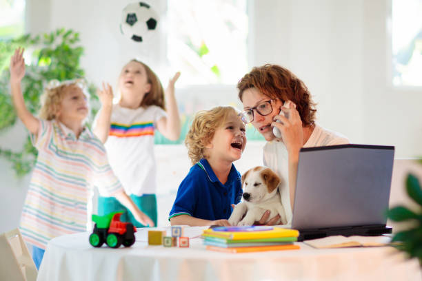 mutter arbeitet von zu hause aus mit kindern. quarantäne. - white dog audio stock-fotos und bilder