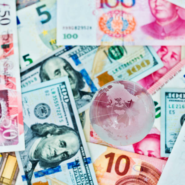 istock Glass globe and international currency notes 1218496274