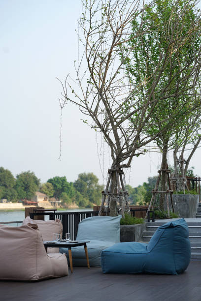 istock Bean bags seating and low timber for dining set with river background 1218497165