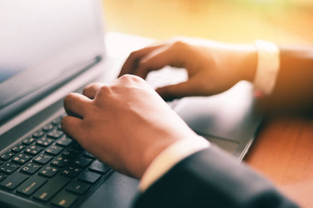 istock Male hand typing on keyboard concept - Businessman working on keyboard computer laptop man sitting on the table and using internet technology at workplace in office 1218498262