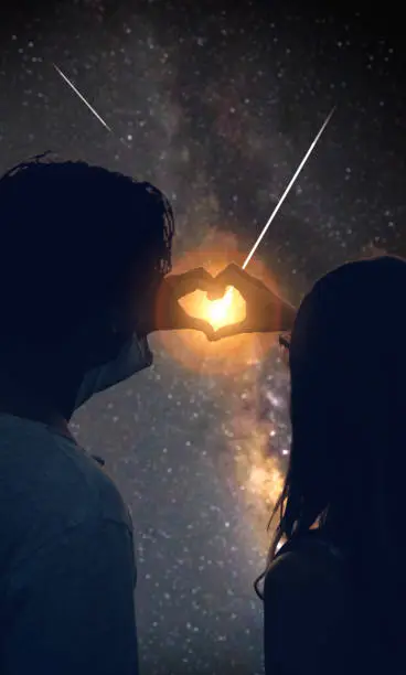 Couple making heart shape under the starry skies.