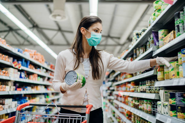 Woman preparing for pathogen virus pandemic spread quarantine.Choosing nonperishable food essentials.Budget buying at a supply store.Pandemic quarantine preparation.Emergency to buy list mujer que se prepara para la cuarentena de propagación de la pandemia del virus patógeno. elegir alimentos no perecederos esenciales. presupuesto comprando en una tienda de suministros. preparación de cuarentena pandémica. lista de emergencia para comp