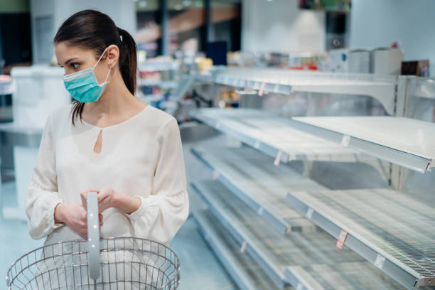 Woman wearing face mask buying in supermarket/drugstore with sold-out supplies.Shopper panic buying and hoarding leading to the unsustainable market.Woman preparing for pathogen virus pandemic stock photo