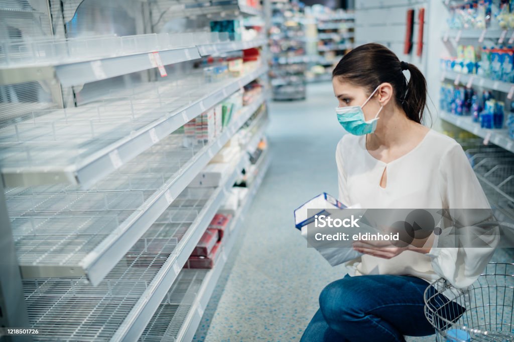 Shopping during the epidemic.Buyer wearing a protective mask.Shopping for enough food and cleaning products.Pandemic quarantine preparation.Pandemic quarantine preparation.Sold out household supplies Sold Out Stock Photo