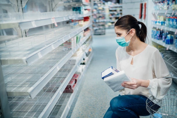 Shopping during the epidemic.Buyer wearing a protective mask.Shopping for enough food and cleaning products.Pandemic quarantine preparation.Pandemic quarantine preparation.Sold out household supplies stock photo