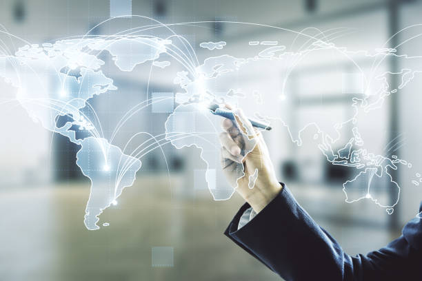 istock Man hand with pen working with abstract graphic digital world map with connections on blurred office background, globalization concept. Multiexposure 1218503471