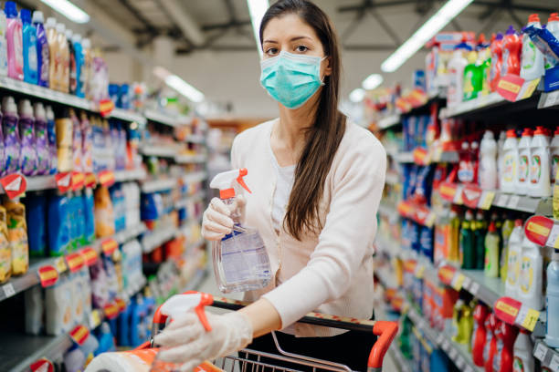 Woman wearing protective mask preparing for virus pandemic spread quarantine.Hygiene, cleaning and disinfection products.Preventive measures and protection.Supply shopping during the epidemic. stock photo