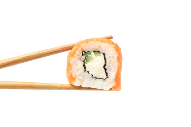 istock Chopsticks with sushi roll isolated on white background 1218511349