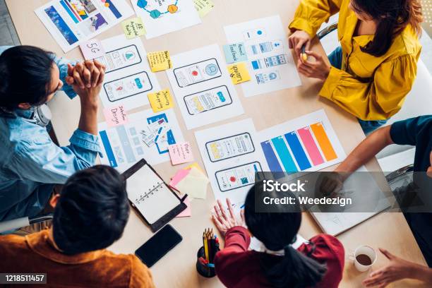 Top View Asian Ux Developer And Ui Designer Brainstorming About Mobile App Interface Wireframe Design On Table With Customer Brief And Color Code At Modern Officecreative Digital Development Agency Stock Photo - Download Image Now