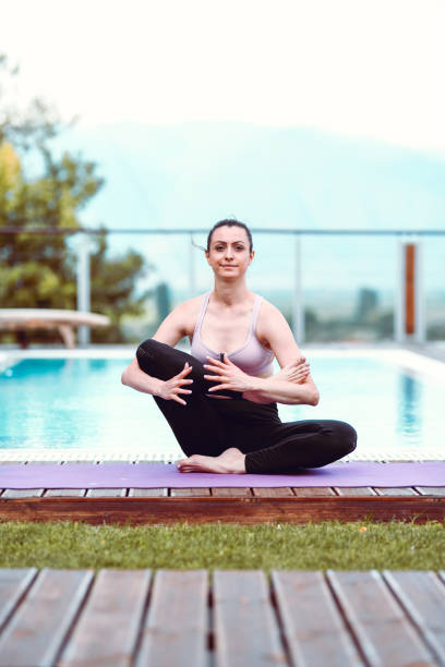 istock Female Showing Advanced Yoga Stretches By The Pool 1218512864