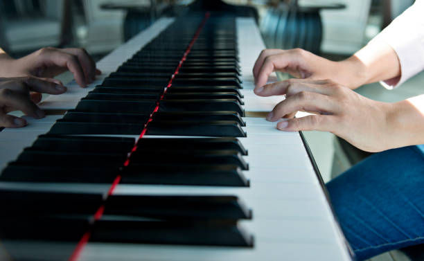 istock Woman hands playing piano 1218513265